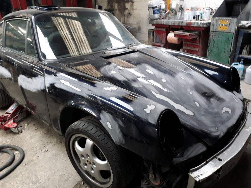 Voiture en réparation, peinture incomplète.