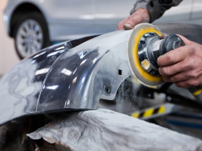 Polissage d'une pièce automobile en cours.