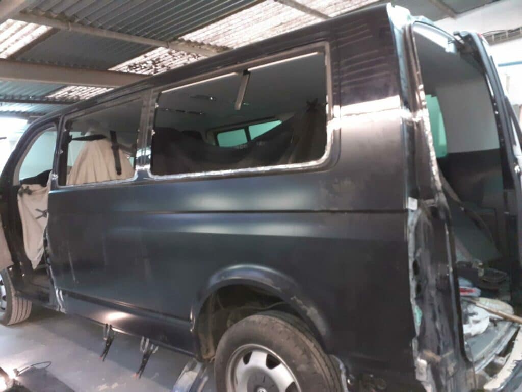 Véhicule en réparation, carrosserie noire.