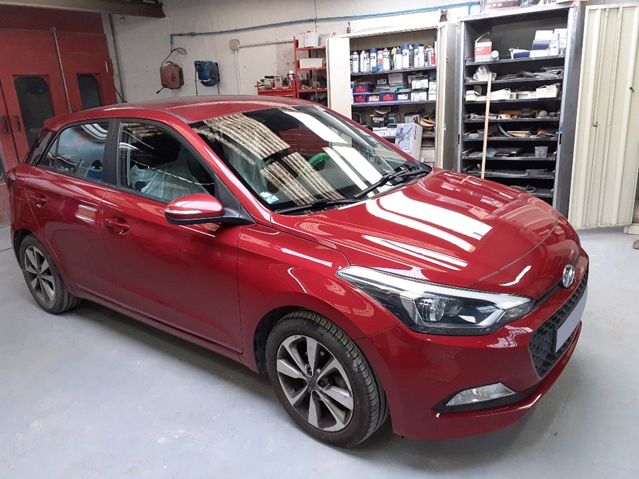 Voiture rouge brillante dans un garage.