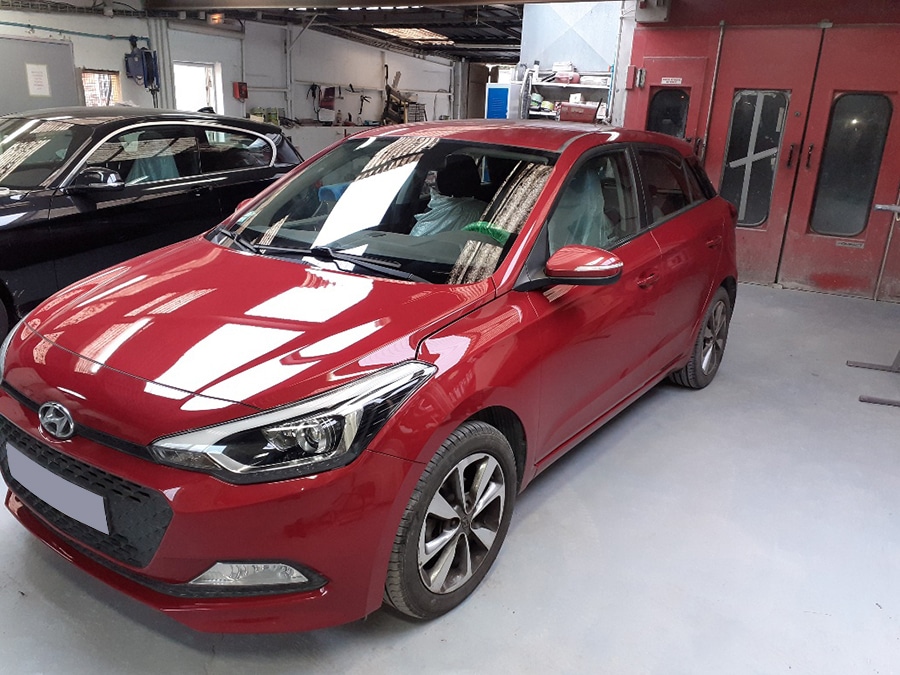 Voiture rouge après dans un garage.